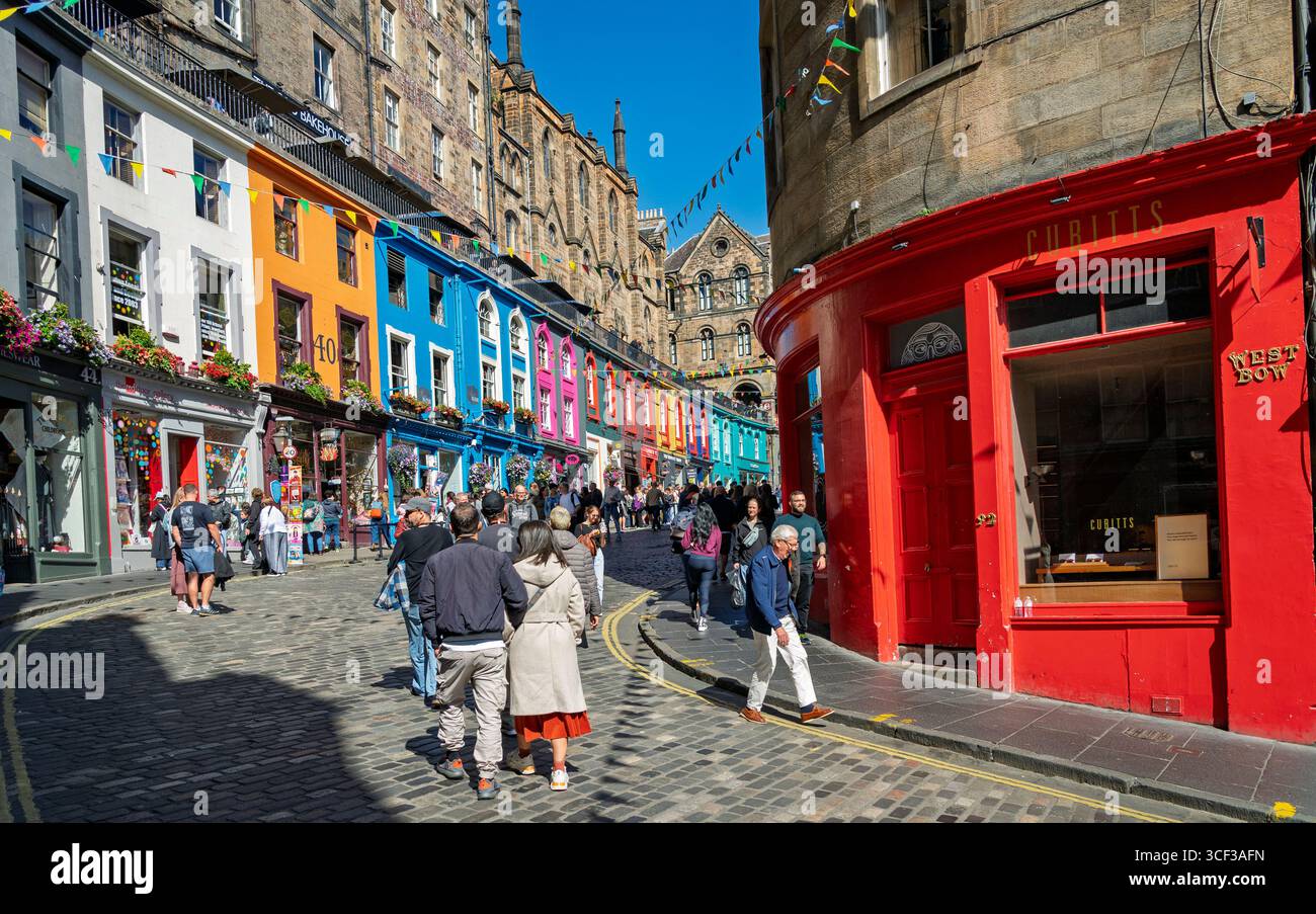Édimbourg, Écosse, Royaume-Uni. 20 août 2025. Vues sur la vieille ville d'Édimbourg pendant Fringe et Festival International avec bars et restaurants en plein air très occupés sous un soleil chaud. Pic ; touristes sur la célèbre rue Victoria avec des vitrines colorées. Iain Masterton/Alamy Live News. Banque D'Images