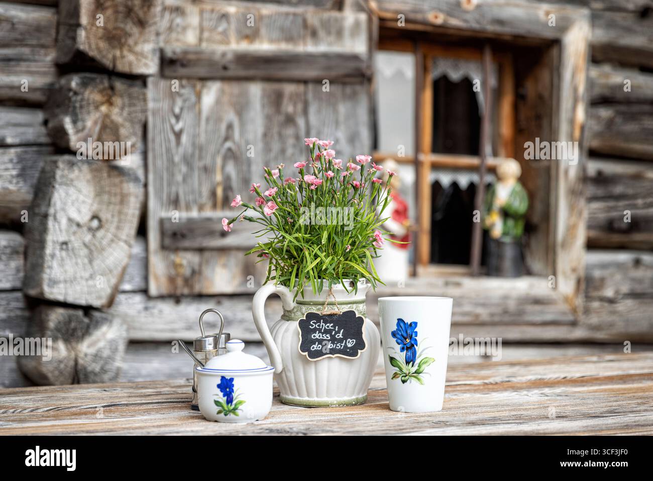 Tasse à boire, cruche avec bouquet de fleurs et récipient à sucre sur la table d'une cabane de montagne. Ramsau près de Berchtesgaden, Bavière, Allemagne. Banque D'Images