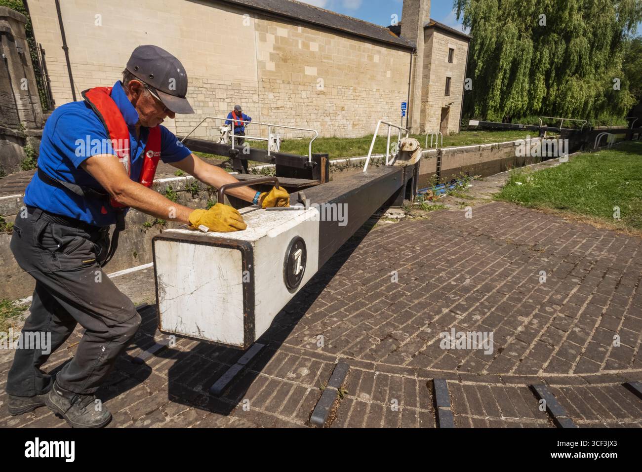 Angleterre, Somerset, Bath, le canal Kennet et Avon, Widcombe Lock et Thimble Mill Lock, Men Opening Lock Gates Banque D'Images