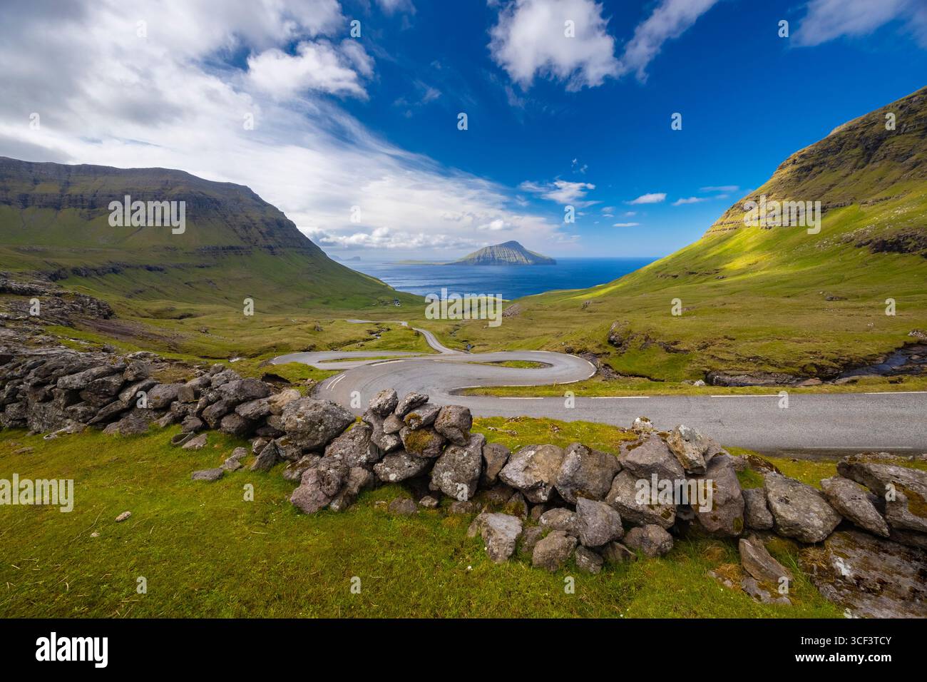 Vue d'une route sinueuse menant à l'île de Koltur en arrière-plan. Streymoy, Torshavnar district, Îles Féroé, Danemark, Scandinavie. Banque D'Images