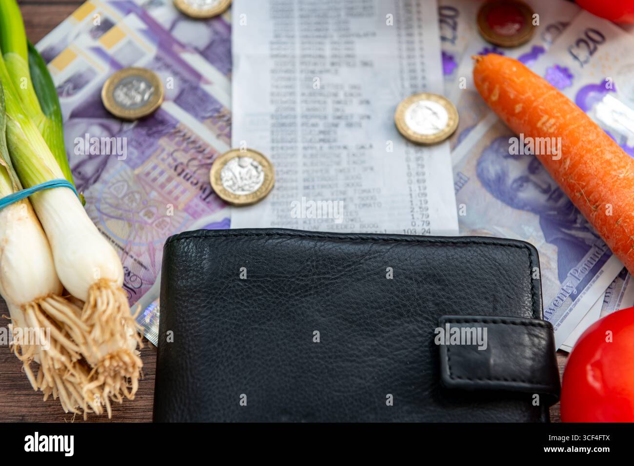 Un concept de coût de la vie au Royaume-Uni avec des billets de banque en livres sterling, un reçu d'épicerie, un sac à main et quelques épiceries de légumes. Banque D'Images