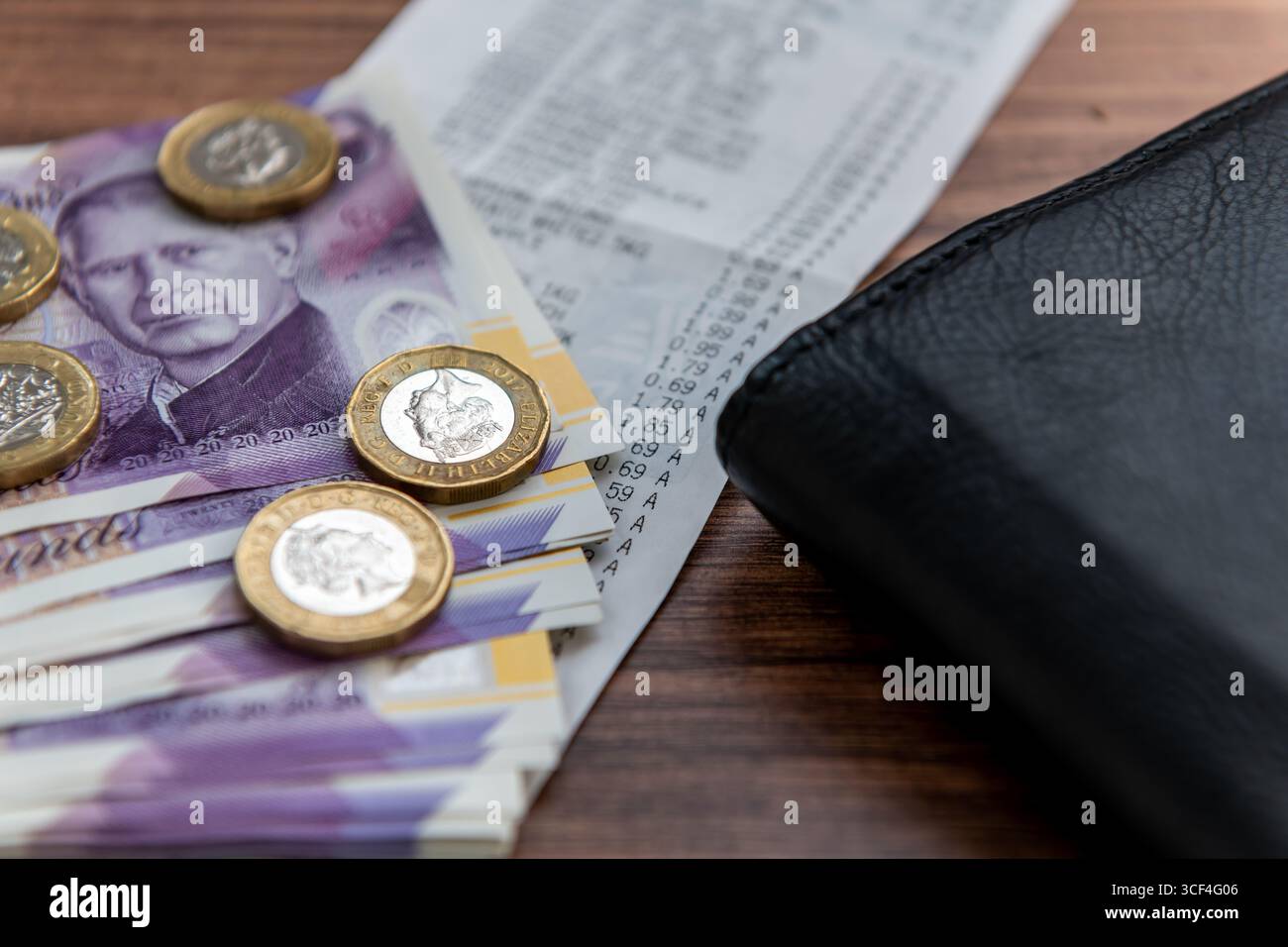 Un concept de coût de la vie au Royaume-Uni avec des billets de banque et des pièces en livres sterling, un reçu d'épicerie et un porte-monnaie. Banque D'Images
