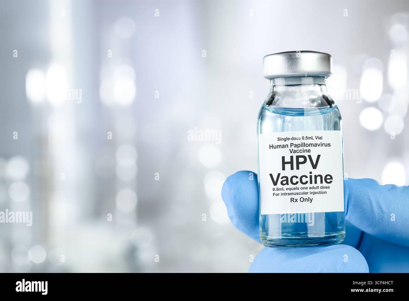 Concept de soins avec une main en bleu gants médicaux holding, HPV Virus du papillome humain, vaccin flacon Banque D'Images