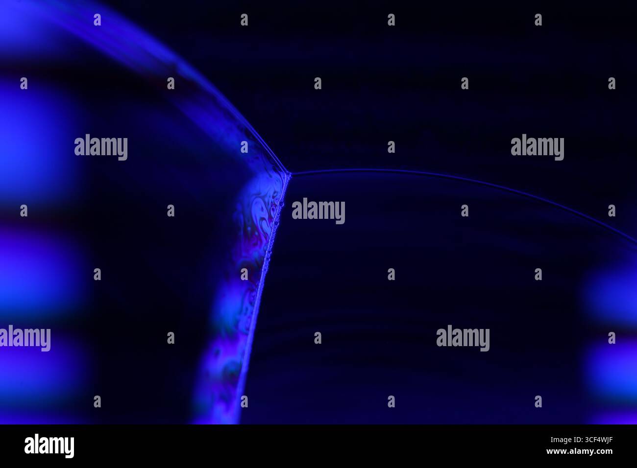 Film fluide violet, fond fluide, ondes plates, mouvement lisse, espace de copie sombre, abstraction d'encre violette Banque D'Images