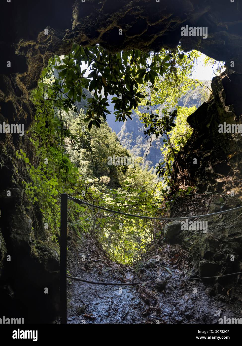 Vue sur le paysage de montagne depuis un tunnel sur le sentier de randonnée le long de la Levada do Caldeirao Verde sur Madère. Banque D'Images