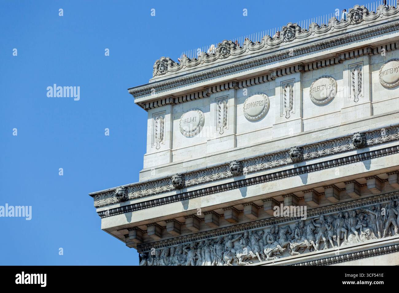 Détail de l'arc de triomphe montrant ses frises ornées et sculptures de tête de lion avec des touristes au-dessus Banque D'Images