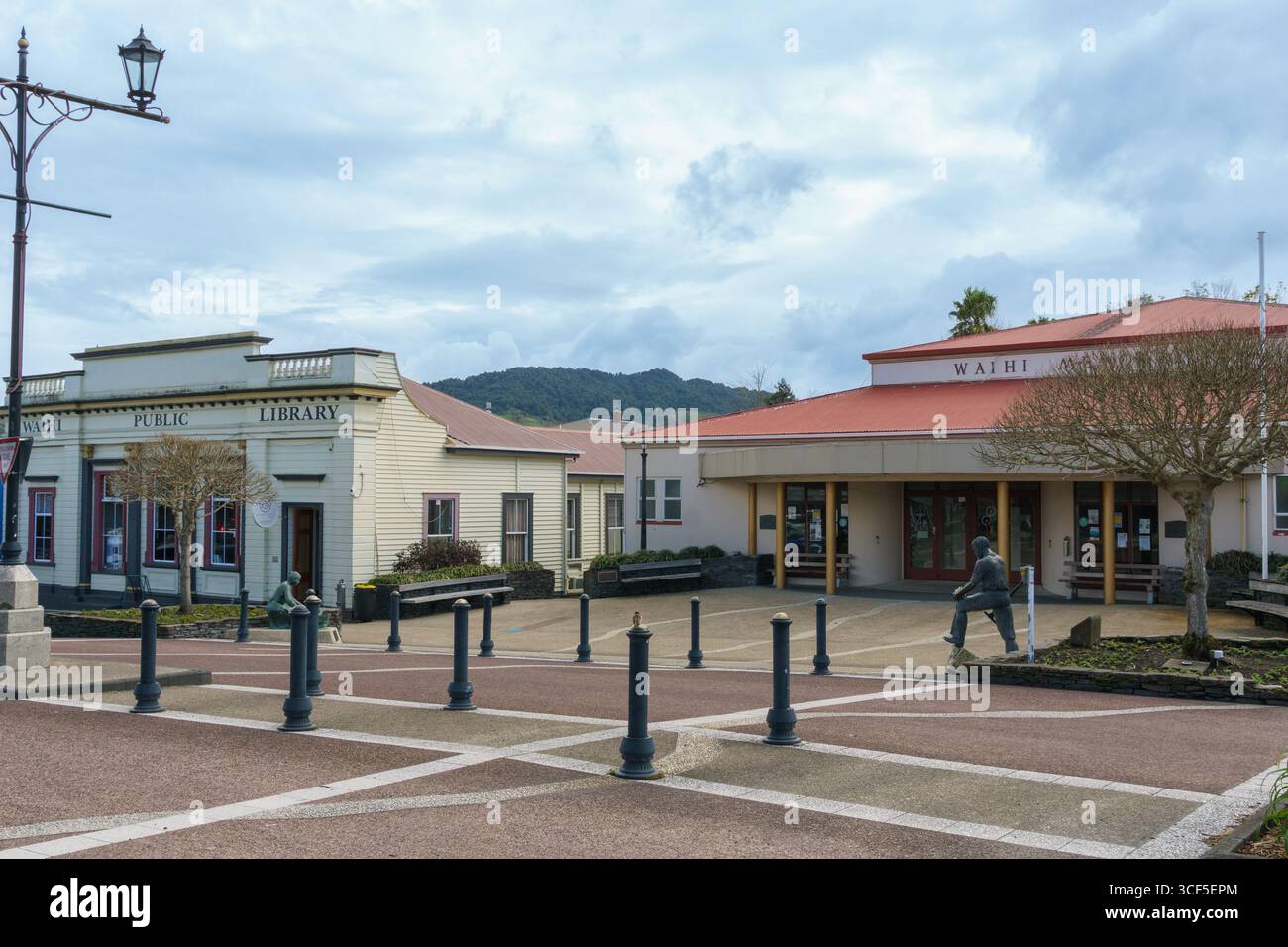 Waihi Nouvelle-Zélande - 18 août 2025 ; Waihi public Library et War Memorial Hall bâtiments avec des sculptures en bronze dans la scène de rue. Banque D'Images