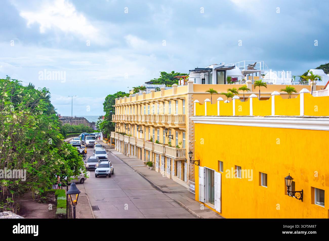Vue panoramique sur une rue animée dans le centre historique de Carthagène, Colombie, avec des bâtiments colorés et de la verdure. Banque D'Images