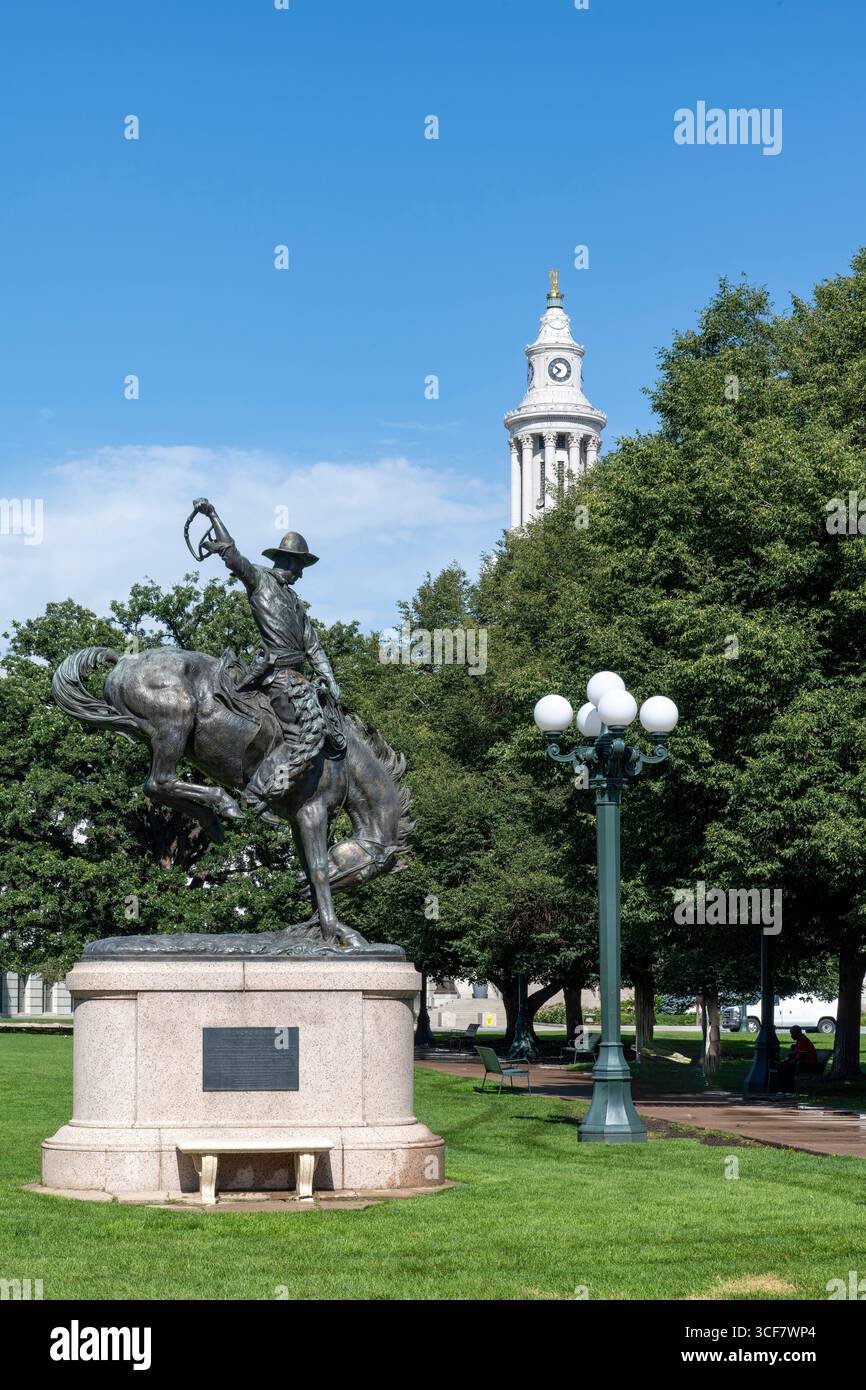 Denver, CO, États-Unis-11 juin 2025 ; statue de Bronco Buster dans le Civic Center Park avec tour de l'horloge du conseil municipal de Denver en arrière-plan Banque D'Images
