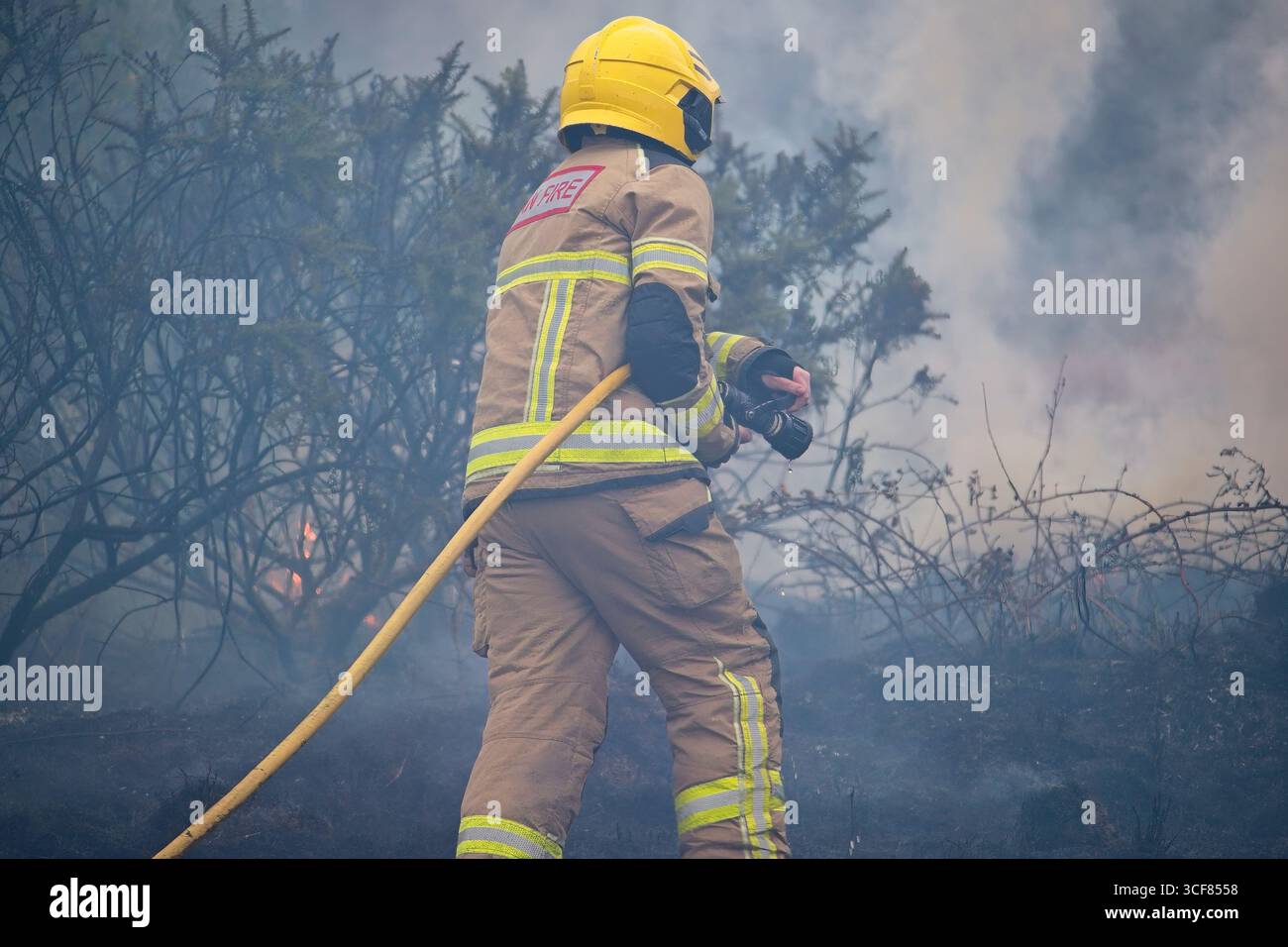 Pompiers face à un incendie gorse à Amlwch. Banque D'Images