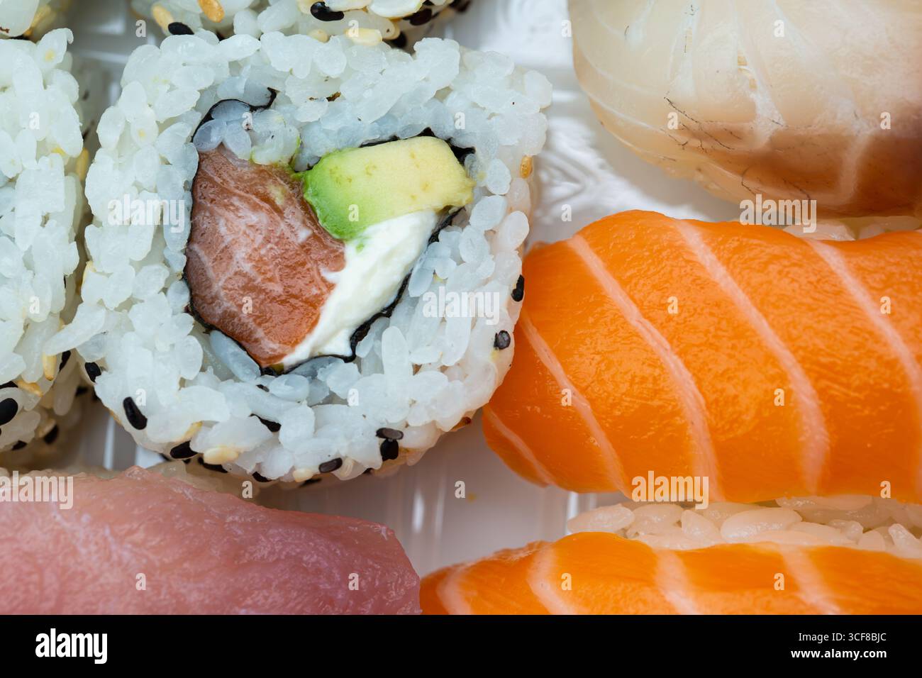 Assortiment de sushis haut de gamme avec nigiri de saumon, rouleaux d'avocat et garniture de gingembre. Parfait pour les menus de restaurant, blogs culinaires, cuisine japonaise ma Banque D'Images