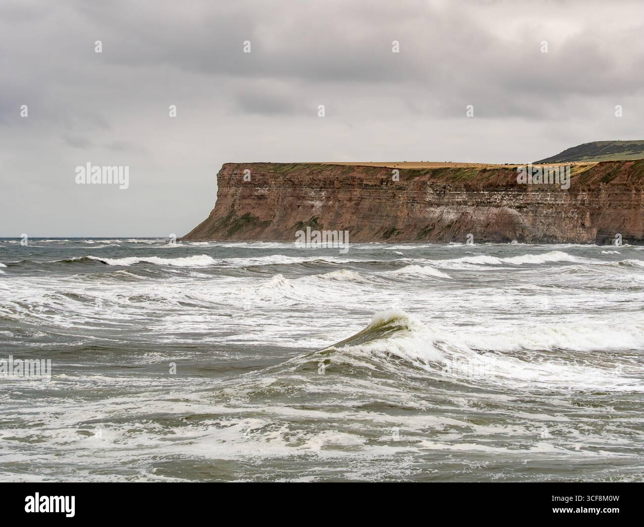 Les falaises spectaculaires et escarpées de Hunt Cliff, avec des vagues bruyantes de la mer du Nord, à Saltburn-by-the-Sea, sur la côte du Yorkshire du Nord, au Royaume-Uni. Banque D'Images