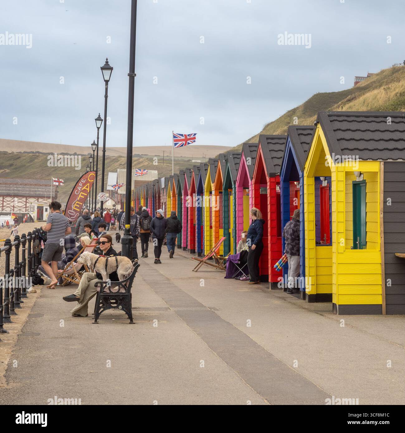 Les gens marchent et se détendent le long de la promenade à côté des cabanes de plage colorées à Saltburn-by-the-Sea, une ville côtière populaire dans le North Yorkshire, Royaume-Uni. Banque D'Images