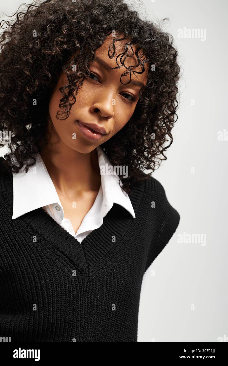 Une jeune belle femme dans une tenue élégante respire l'élégance tout en posant dans un cadre de studio. Banque D'Images