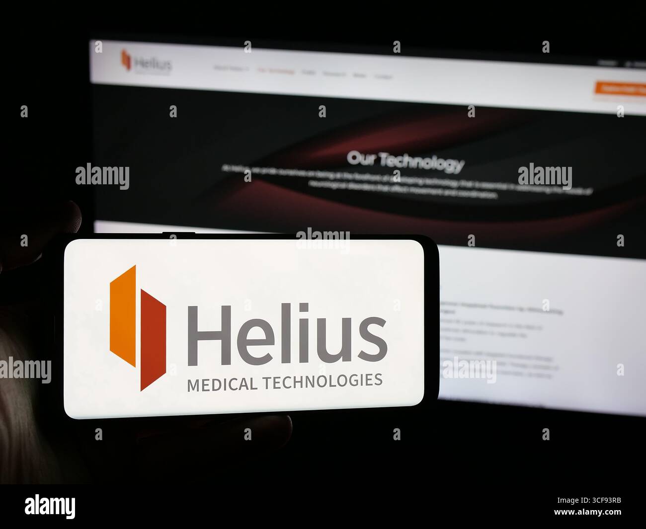 Stuttgart, Allemagne - 08-20-2025 : personne tenant un smartphone avec le logo de la société américaine Helius Medical technologies Inc. sur l'écran en face du site Web. Banque D'Images