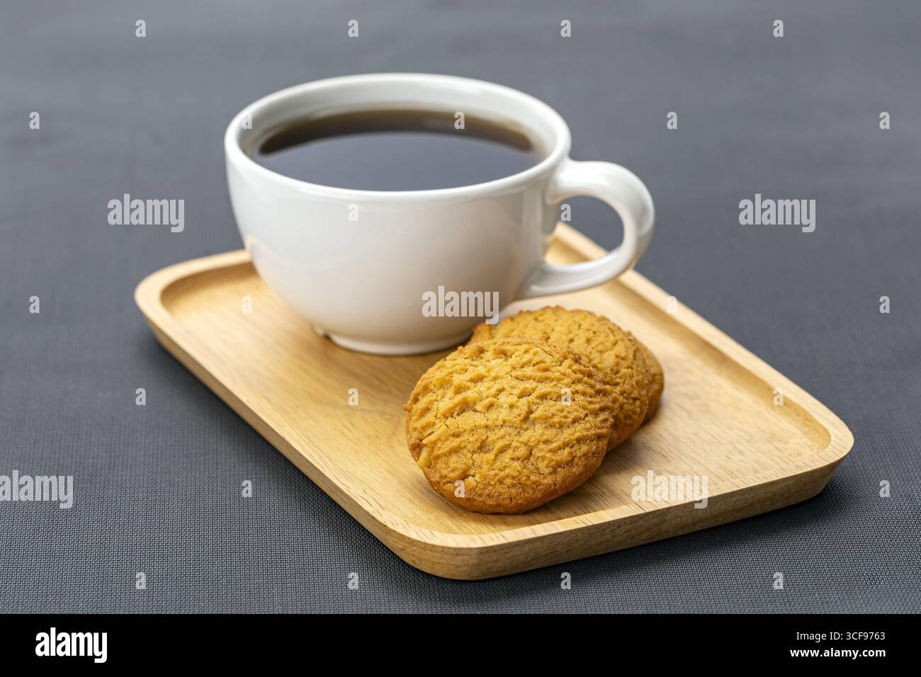 Un americano biscuit au café plateau en bois tasse blanche boisson chaude collation petit déjeuner caféine relaxation Cozy Delicious Treat simple présentation gris Banque D'Images