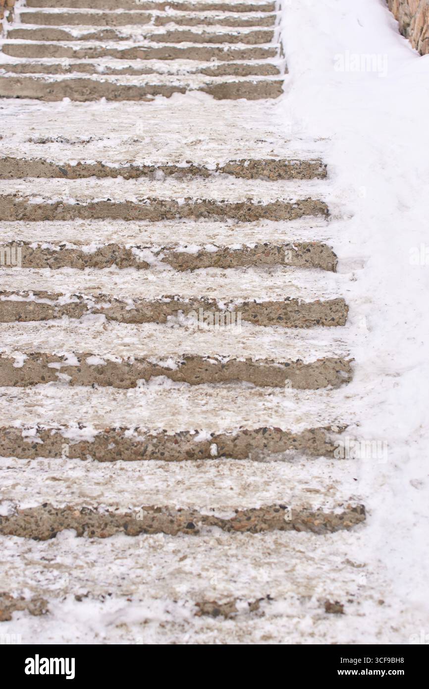 Marches en béton recouvertes de neige avec léger dépoussiérage de neige et de glace en hiver. Banque D'Images