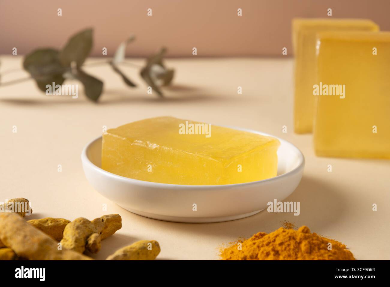 Barres de savon faites à la main, poudre et racine de curcuma sur fond beige. Produit de soins de la peau bio parfait pour le bien-être, la beauté et le concept de soins corporels bio Banque D'Images