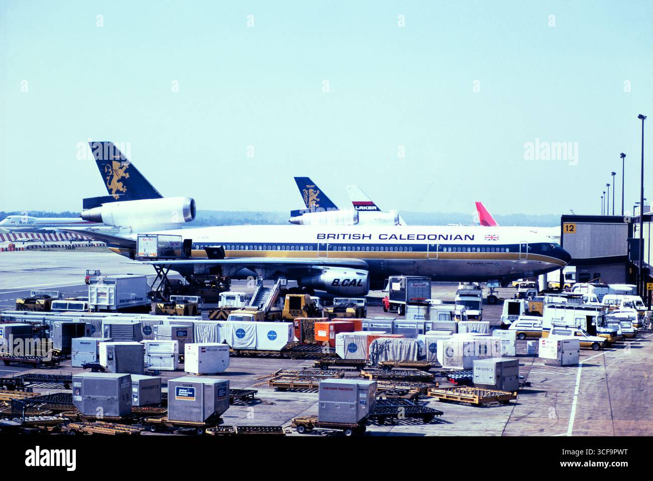 British Caledonian Airways McDonnell Douglas DC-10 avion de ligne G-BEBL, nommé Sir Alexander Fleming, à l'aéroport de Londres Gatwick en 1981. Premier vol 1974, mis au rebut 2008. PAN Am, Cathay Pacific et autres conteneurs à bagages, conteneurs ULD et véhicules aéroportuaires stationnés autour de l'avion Banque D'Images