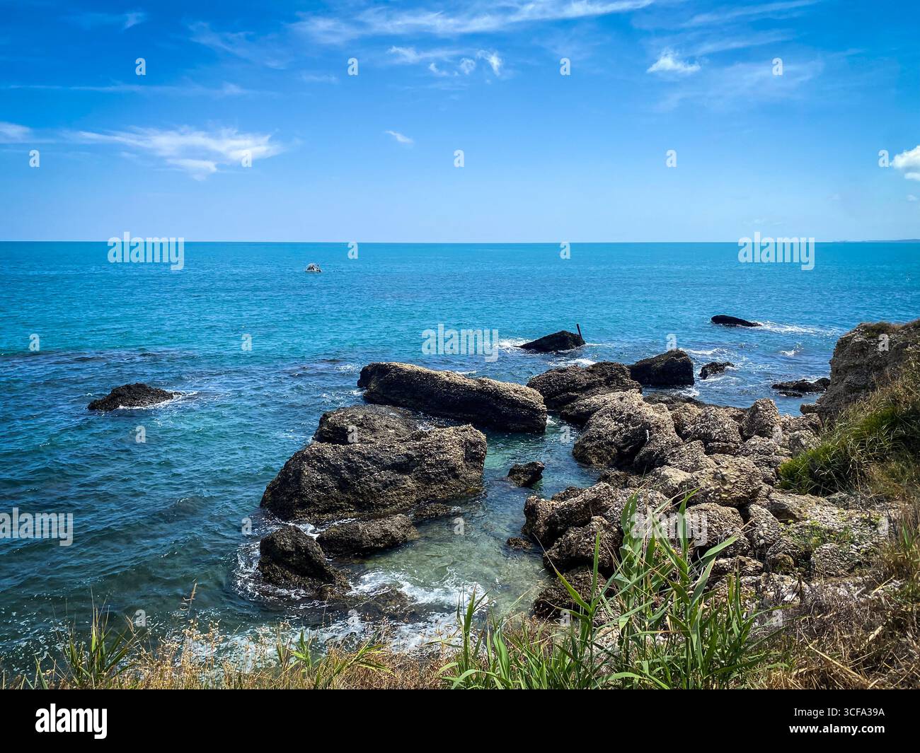 La côte rocheuse de Rocca San Giovanni révèle les eaux turquoises de la mer Adriatique bordant le paysage accidenté des Abruzzes sous la lumière du soleil, révélant scen Banque D'Images