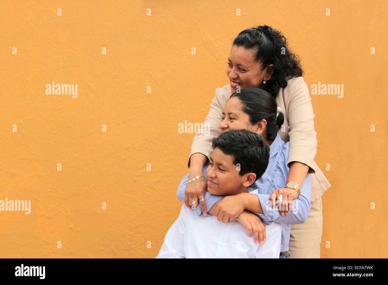 La mère, la fille et le fils latino-américains à la peau foncée montrent leur amour avec des câlins et célèbrent la fête des mères avec leur famille Banque D'Images La mère, la fille et le fils latino-américains à la peau foncée montrent leur amour avec des câlins et célèbrent la fête des mères avec leur famille Banque D'Images