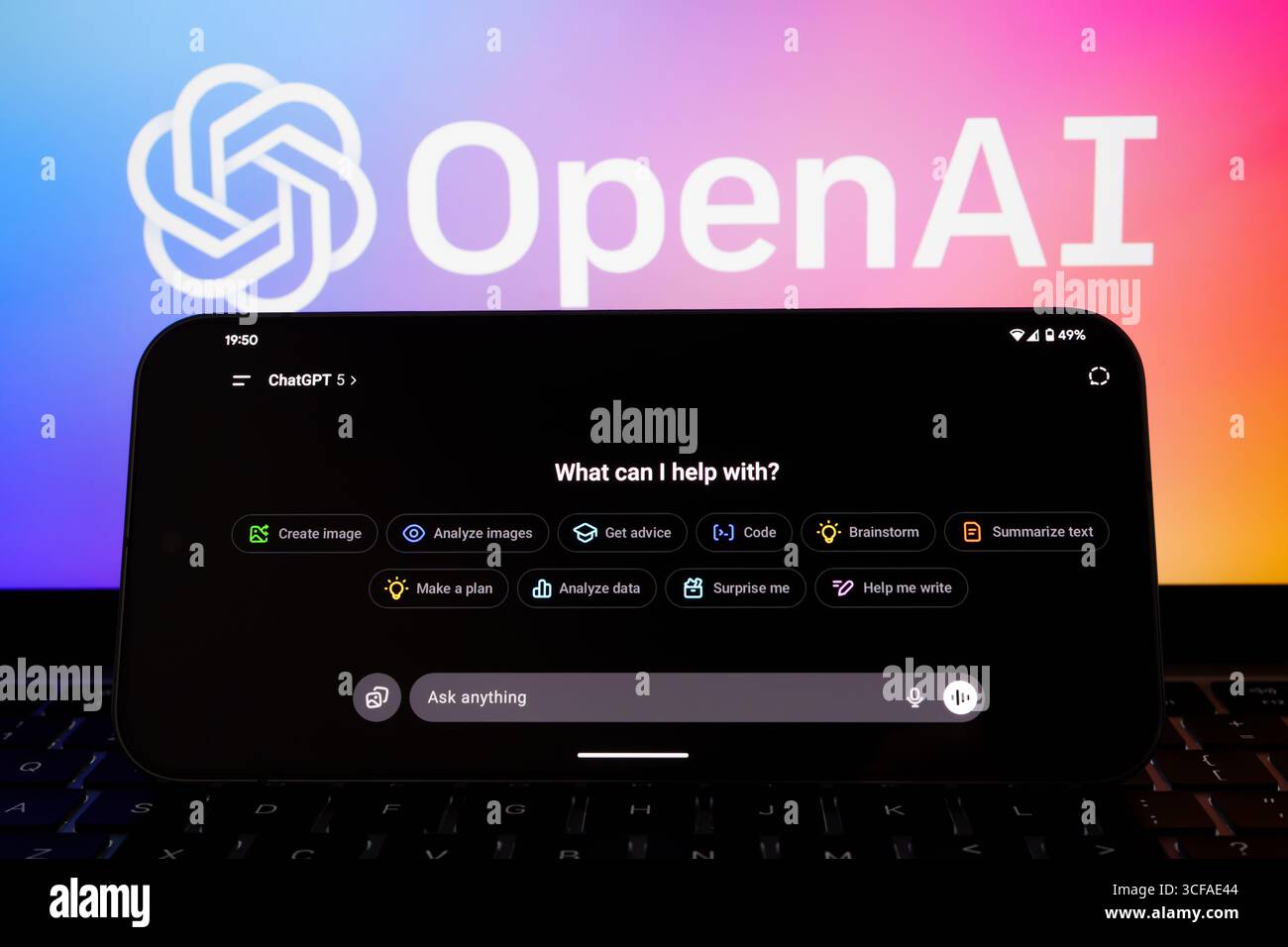 Interface ChatGPT 5 en paysage sur smartphone avec clavier d'ordinateur portable et fond de logo OpenAI dégradé. Stafford, Royaume-Uni, 21 août 2025 Banque D'Images