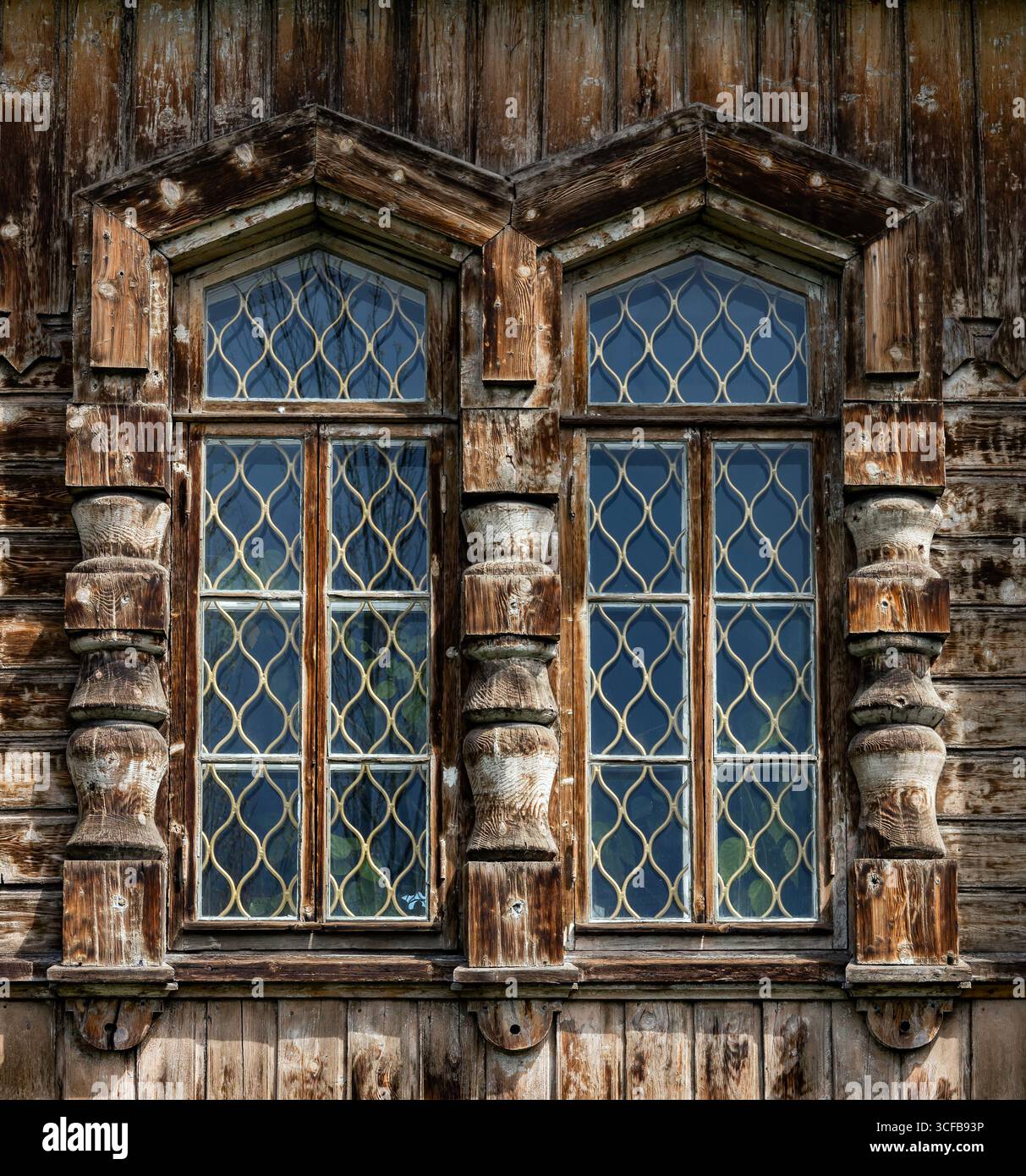 Fenêtres en bois avec barres métalliques dans une vieille maison en bois. Banque D'Images