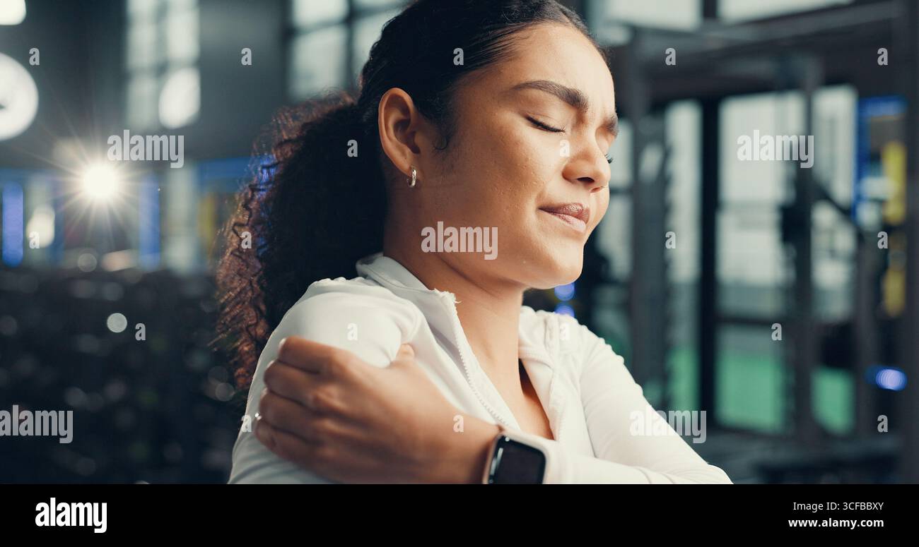 Douleur à l'épaule, forme physique et femme dans le gymnase, blessure articulaire et inflammation avec inconfort. Massage, fracturé et personne dans le centre de santé, tension musculaire Banque D'Images