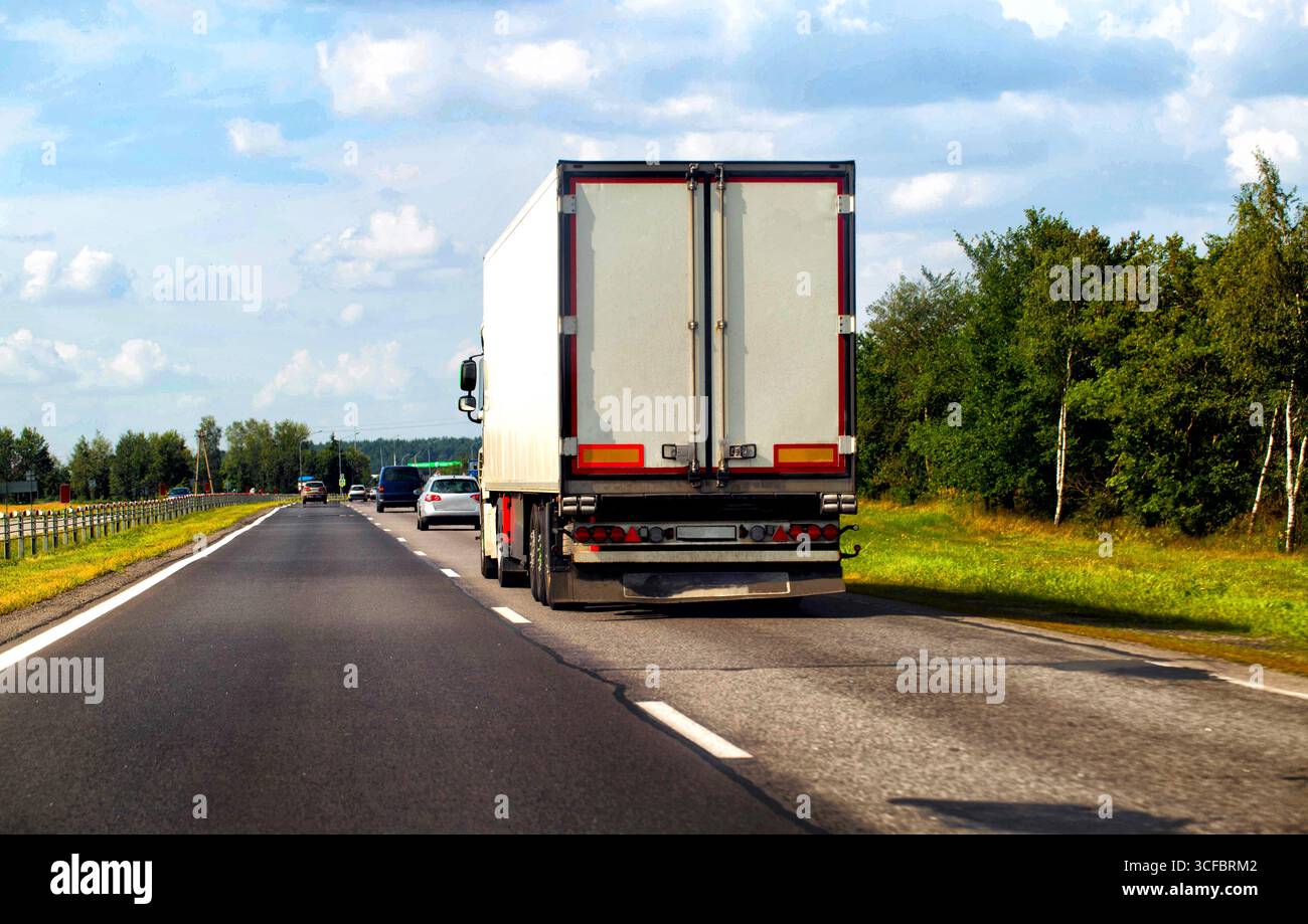 Un camion avec une semi-remorque transporte des marchandises le long de la route en été. Le concept d'une bourse de fret et de transitaires et de camionneurs. Banque D'Images
