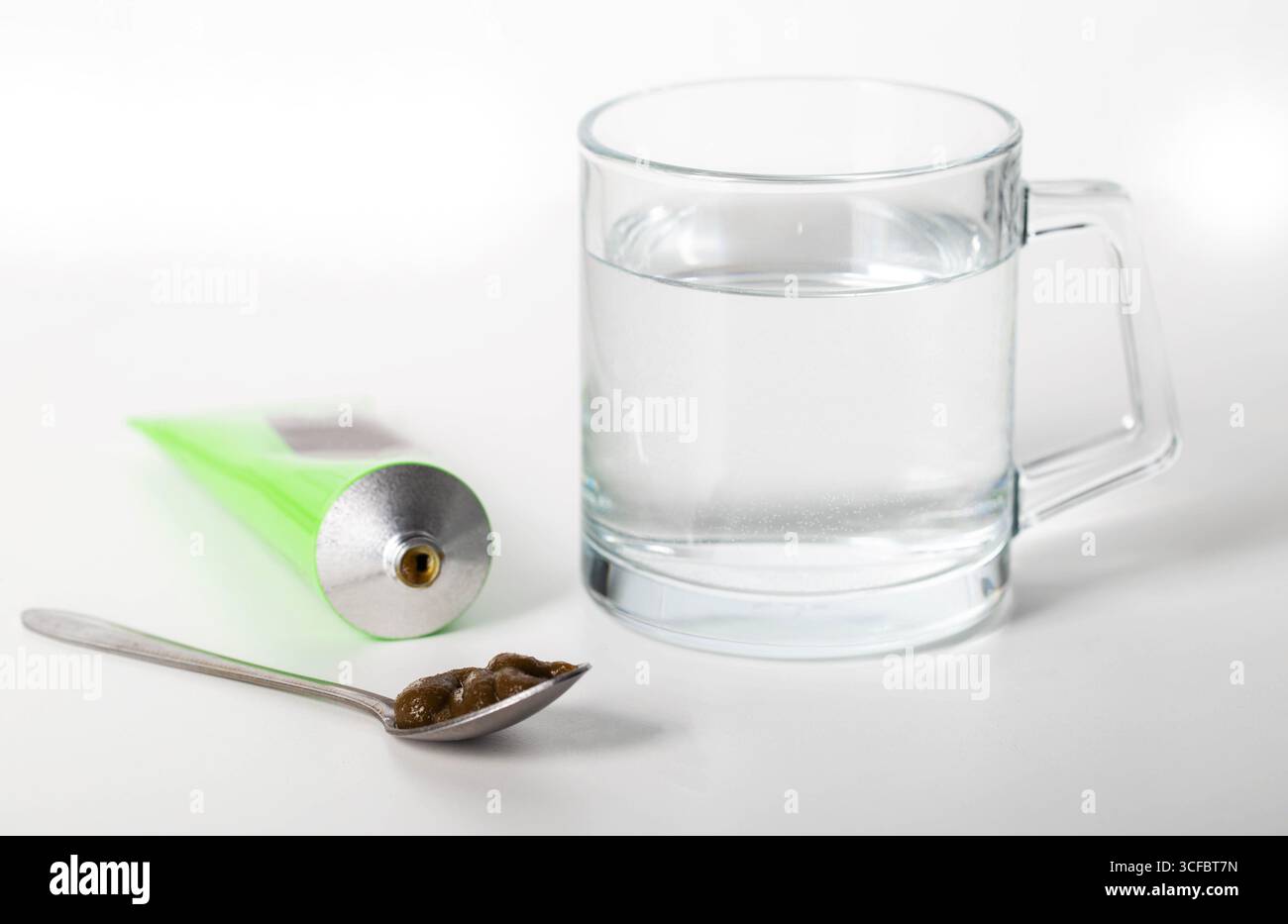 Pâte urologique sur les herbes sur le fond d'un verre d'eau. Traitement des maladies inflammatoires infectieuses de l'appareil urinaire Banque D'Images