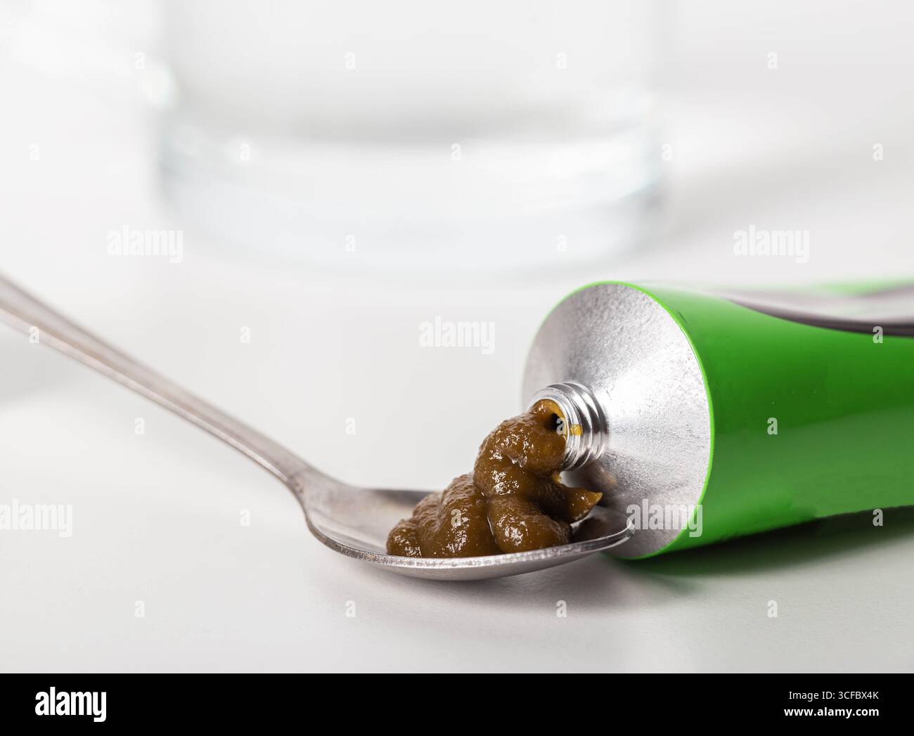 Pâte urologique sur les herbes sur le fond d'un verre d'eau. Traitement des maladies inflammatoires infectieuses de l'appareil urinaire Banque D'Images