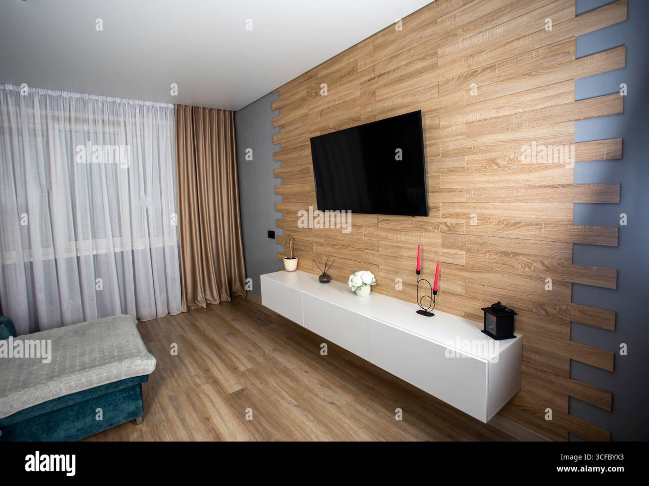 Intérieur moderne dans le salon avec parquet stratifié, armoires murales, télévision LCD et climatisation. Rénovation élégante dans l'appartement Banque D'Images