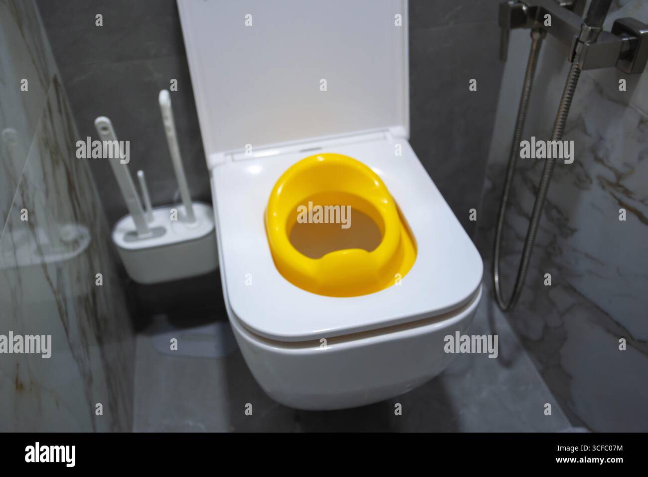 Siège de toilette enfant jaune pour les enfants dans les toilettes. Commodité et confort pour l'enfant sur les toilettes. Banque D'Images