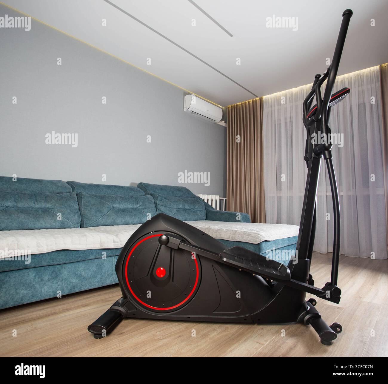 Vélo elliptique moderne dans la chambre à la maison. Concept d'exercice à domicile. Copier l'espace pour le texte Banque D'Images