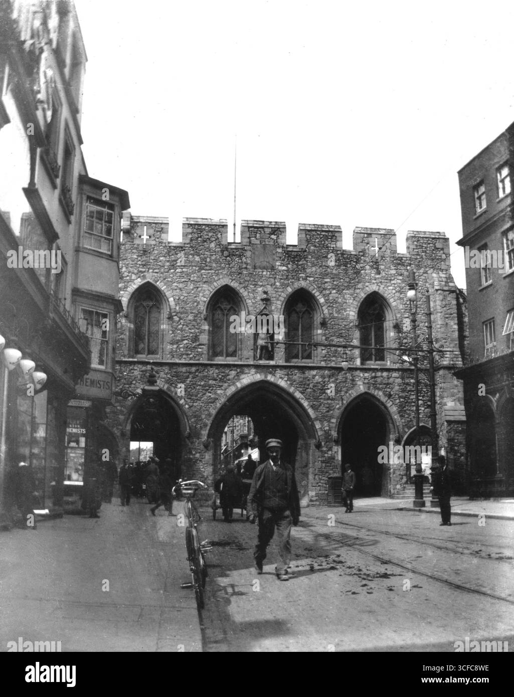 Hampshire, Angleterre. Circa.1905 - une photographie édouardienne de Bargate, une porte médiévale dans le centre-ville de Southampton. Lors de sa construction, vers 1180, Bargate était destiné à être la porte principale de la ville. La vue est prise de la High Street en regardant vers la maison de garde du sud. Les bâtiments de chaque côté n'existent plus. Visible sur la gauche, la pharmacie C. Johnson & son. Banque D'Images