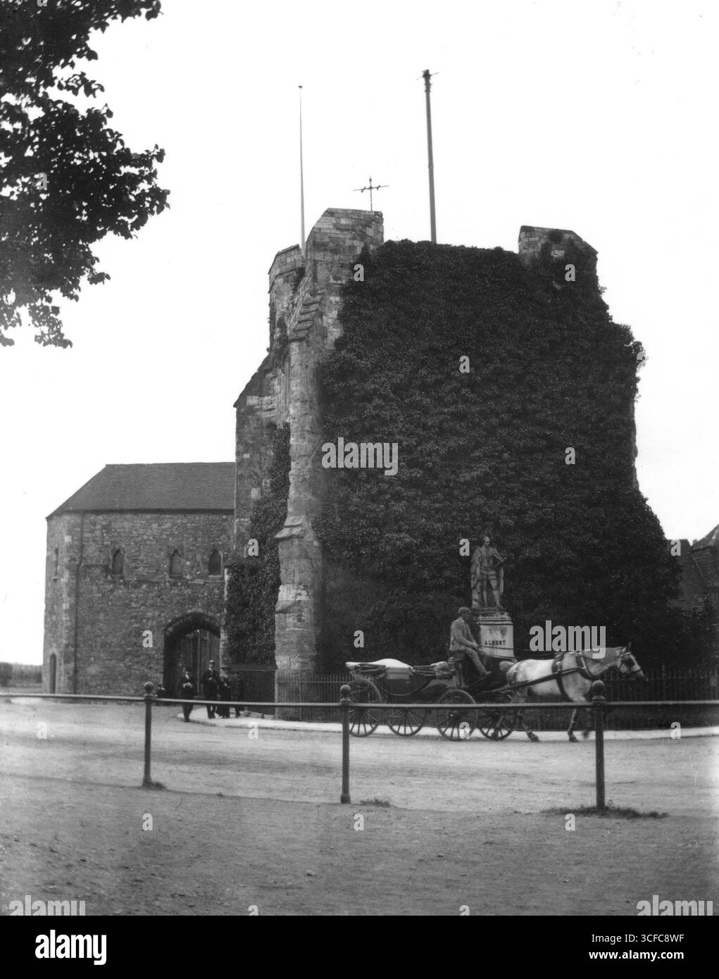 Hampshire, Angleterre. Circa.1905 – photographie édouardienne de la God’s House Tower et de la porte sud, prise depuis Town Quay, Southampton. Ce gatehouse du XIIIe siècle est représenté recouvert de lierre. En face se trouve la statue en terre cuite du prince Albert, qui a été présentée à la ville en 1877 par le député de Southampton, Sir Frederick Perkins. La statue a été enlevée en 1912 et détruite pendant la première Guerre mondiale. Une calèche Landau tirée par des chevaux passe devant le bâtiment. Banque D'Images