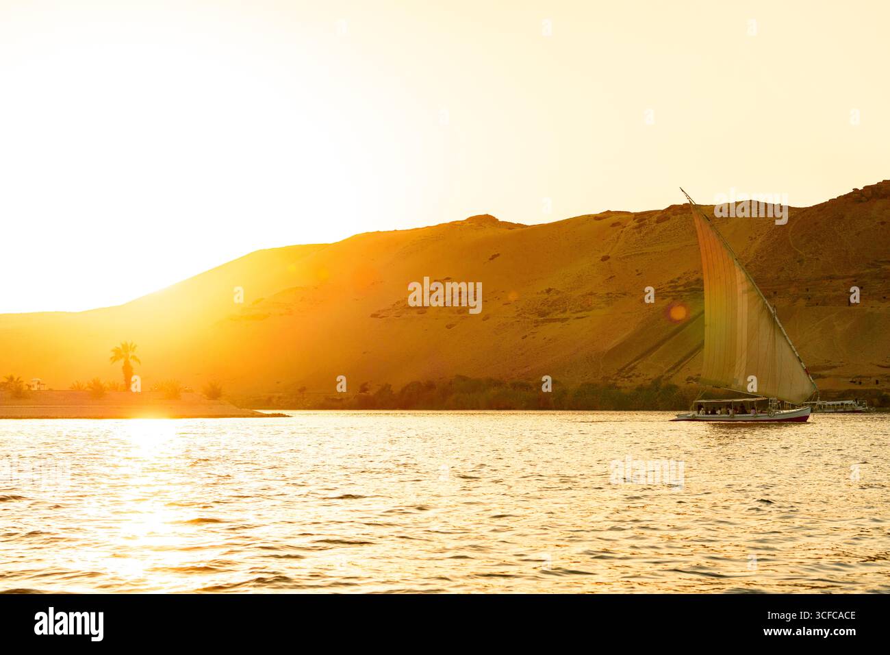 Felucca bateau naviguant sur le Nil au coucher du soleil Banque D'Images