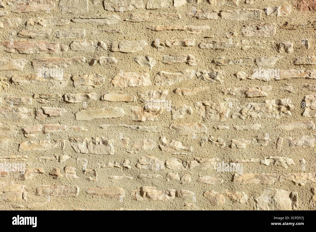 Mur de pierres grises alignées horizontalement maintenues ensemble avec du ciment brun. Vue de face. Banque D'Images