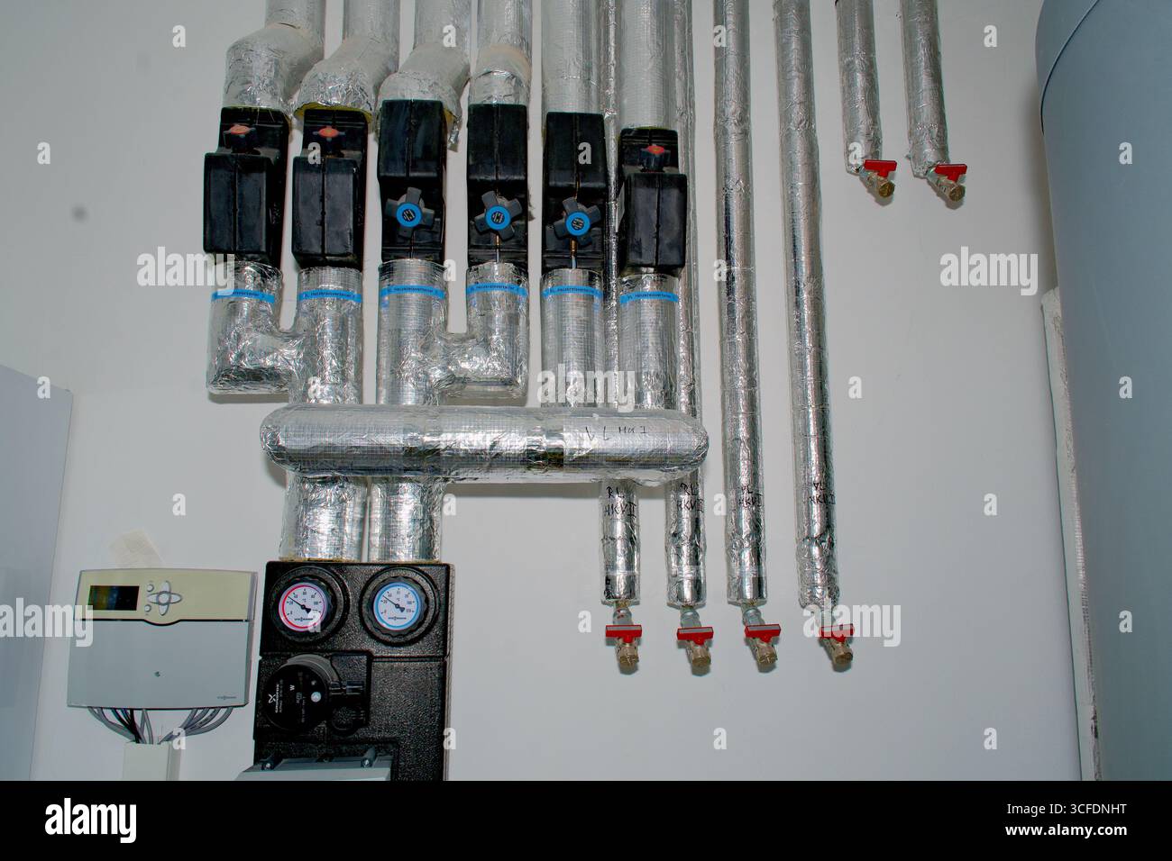 Gros plan d'un collecteur de circuit de chauffage (Heizkreisverteiler) faisant partie d'un système de chauffage domestique, montrant les tuyaux et les connexions. Banque D'Images