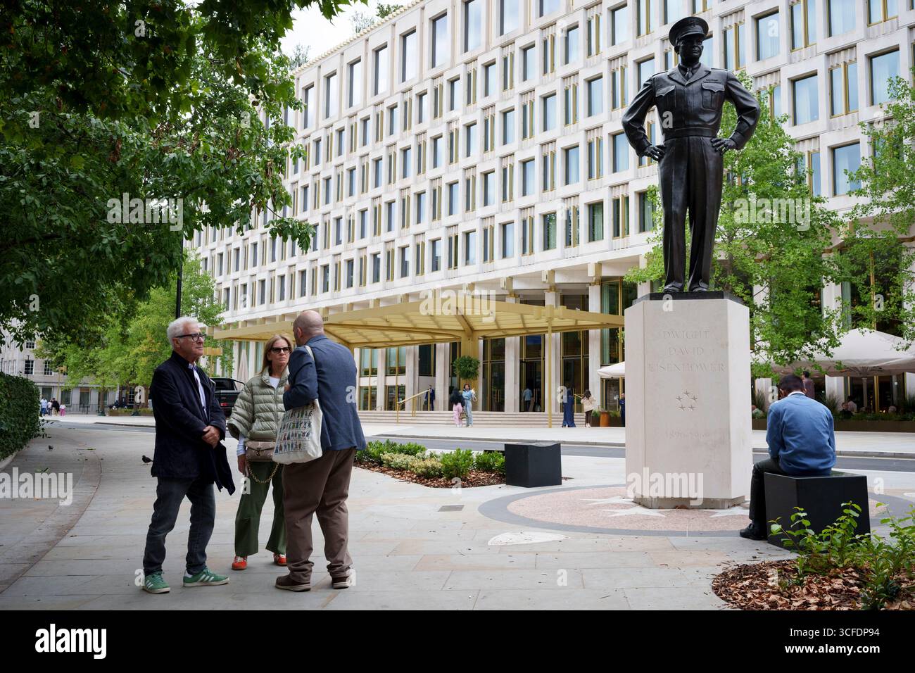 Un guide montre aux touristes la statue de l'ancien président américain Dwight d Eisenhower devant l'hôtel Chancery Rosewood récemment achevé à Grosvenor Square à Mayfair, le 22 août 2025, à Londres, en Angleterre. Le bois de rose a été construit à l'origine en 1960 par Eero Saarinen pour abriter l'ambassade des États-Unis, le lieu pendant des décennies de protestation politique, surtout contre la politique étrangère américaine pendant la guerre du Vietnam. Banque D'Images