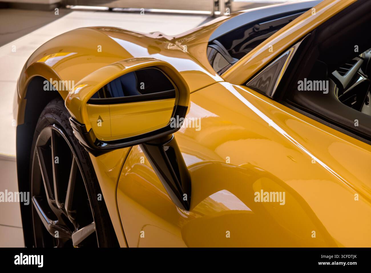 Gros plan sur le rétroviseur latéral d'une voiture jaune. Banque D'Images