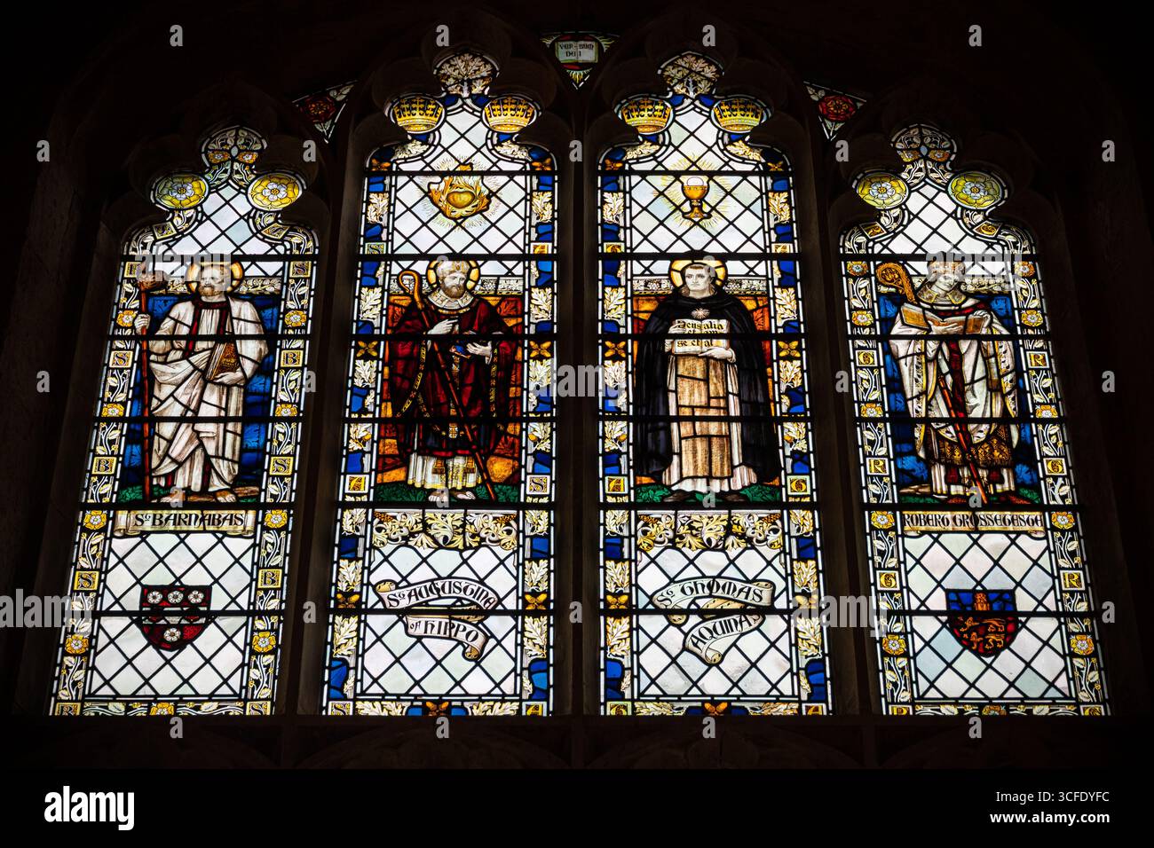 Cambridge, Angleterre. Vitrail dans une chapelle nord de Great St Mary montrant St Barnabas, St Augustin d'Hippo, St Thomas d'Aquin et Robert Banque D'Images