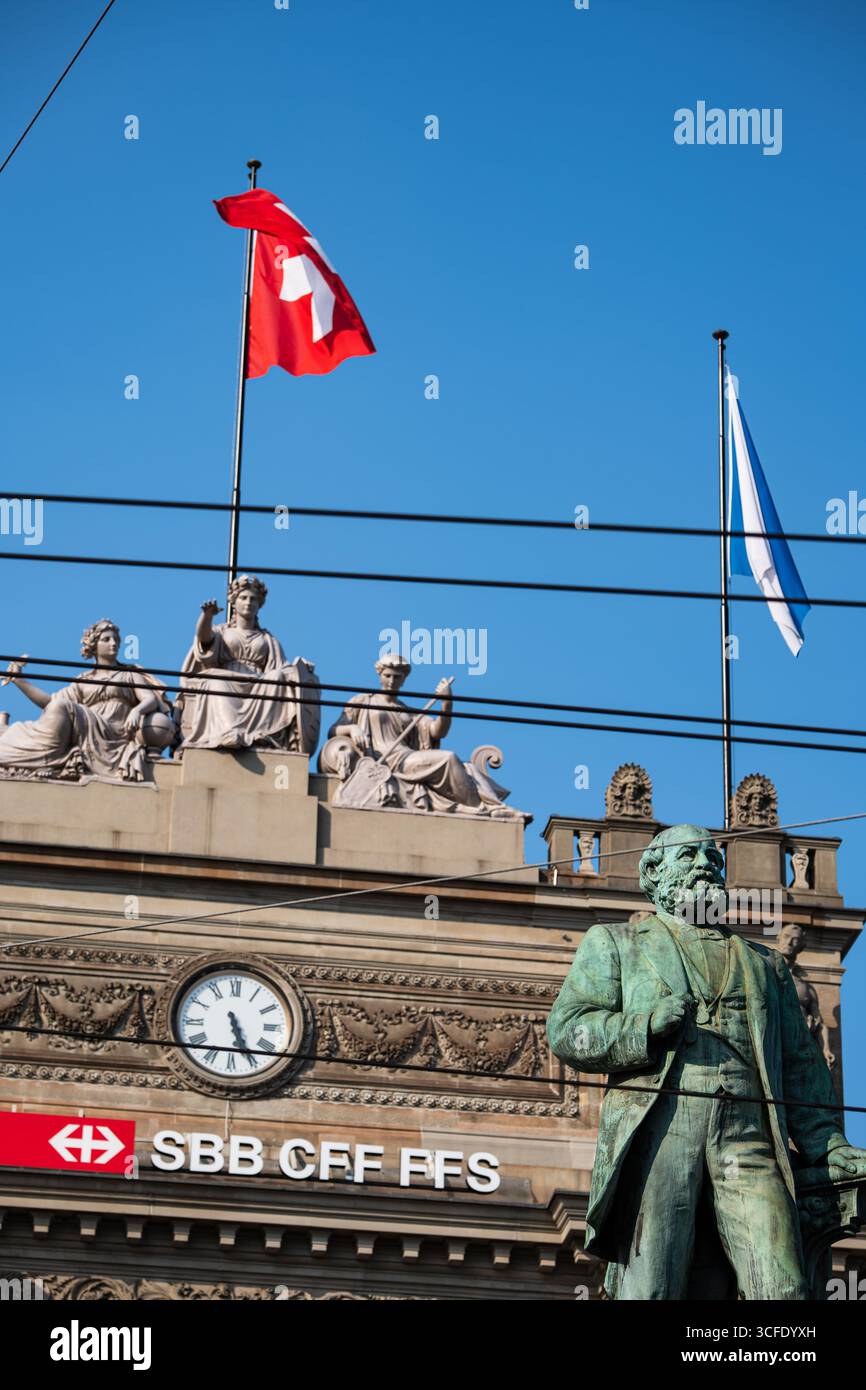 Zurich, Suisse, 19 août 2025. Façade d'entrée du bâtiment de la gare centrale de Zurich HB avec la statue d'Alfred Escher au premier plan. Regardant vers le haut shot, su Banque D'Images