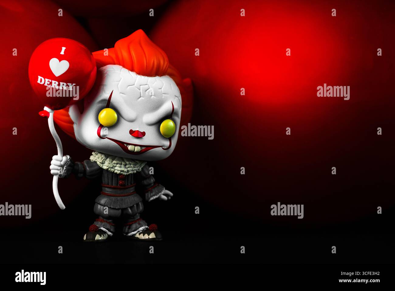 Funko figurine POP vinyle de Pennywise figure personnage du film il avec des ballons rouges et un espace pour le texte sur un fond sombre. editori illustratif Banque D'Images