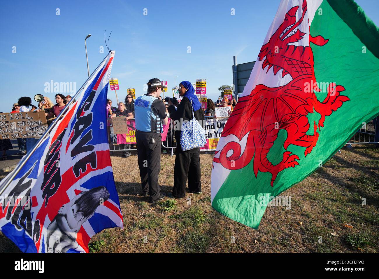 Les gens prennent part au rassemblement Stand Up to Racism et à une contre-manifestation devant le Holiday Inn à l'aéroport de Cardiff. Date de la photo : vendredi 22 août 2025. Banque D'Images Les gens prennent part au rassemblement Stand Up to Racism et à une contre-manifestation devant le Holiday Inn à l'aéroport de Cardiff. Date de la photo : vendredi 22 août 2025. Banque D'Images