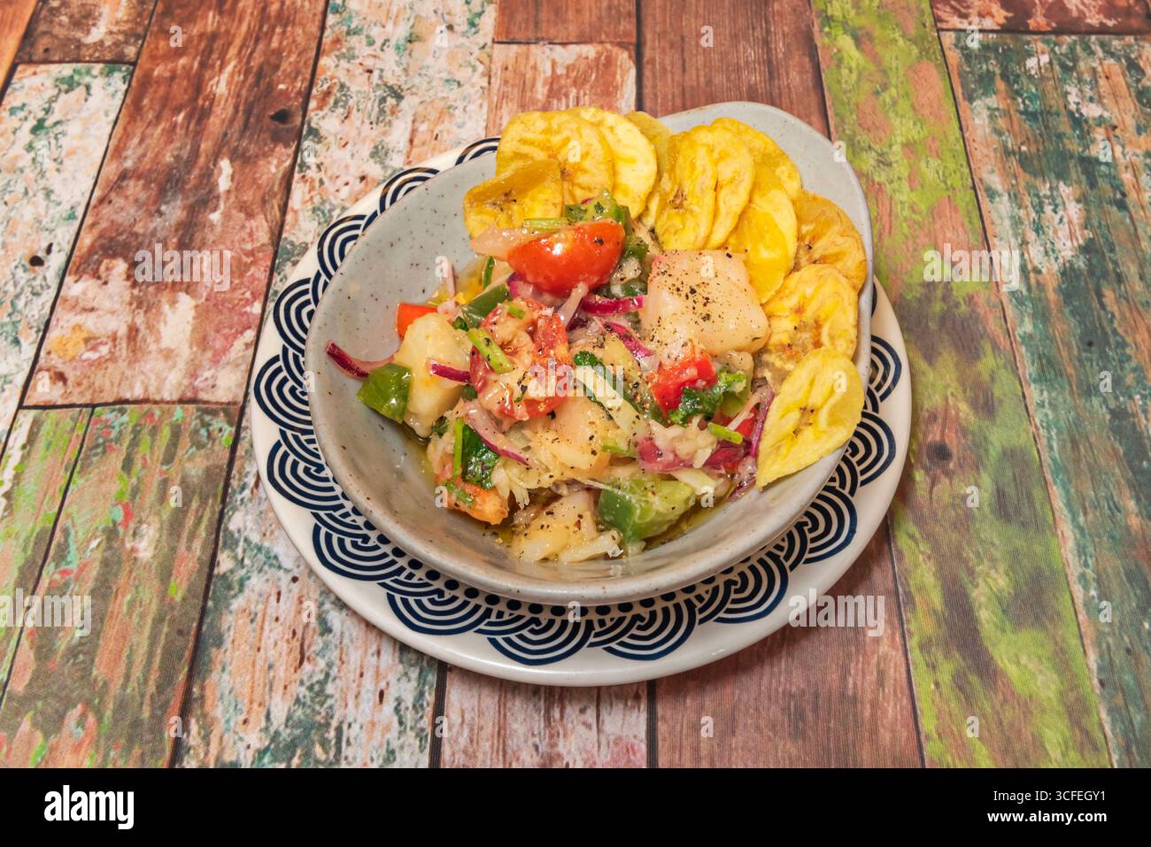 Ceviche de sole parfaitement cuite, avec croustilles de patates douces violettes, maïs cancha et feuilles de laitue violettes comme base Banque D'Images