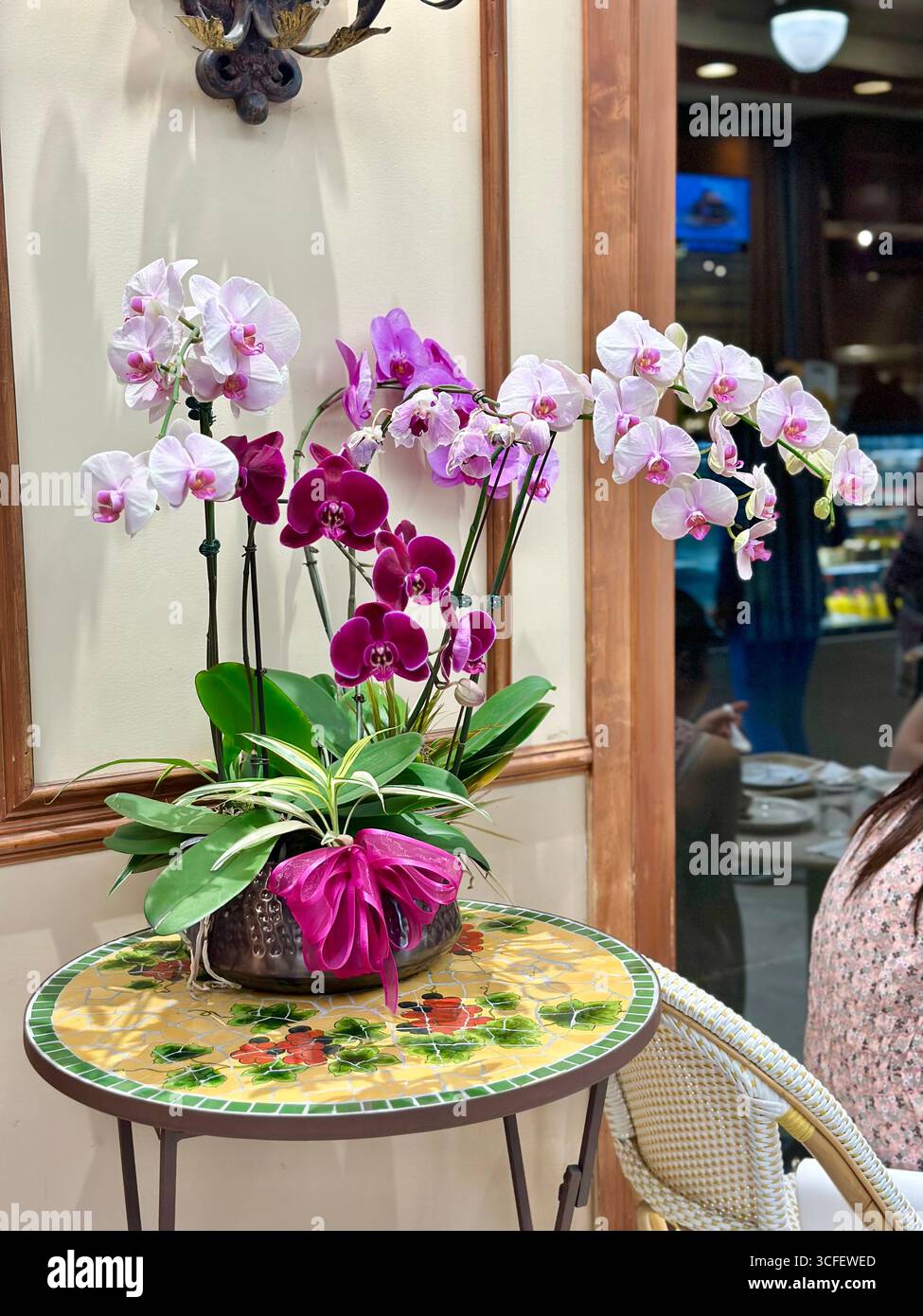 Arrangement élégant d'orchidées sur la table mosaïque dans le café intérieur - Image de stock capturée avec un smartphone