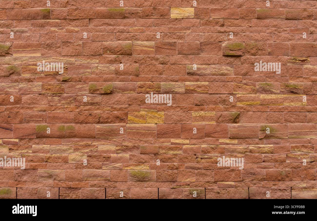 Mur de briques rouges. Fond de texture de mur de calcaire de couleur rouge avec pierre naturelle rugueuse Banque D'Images