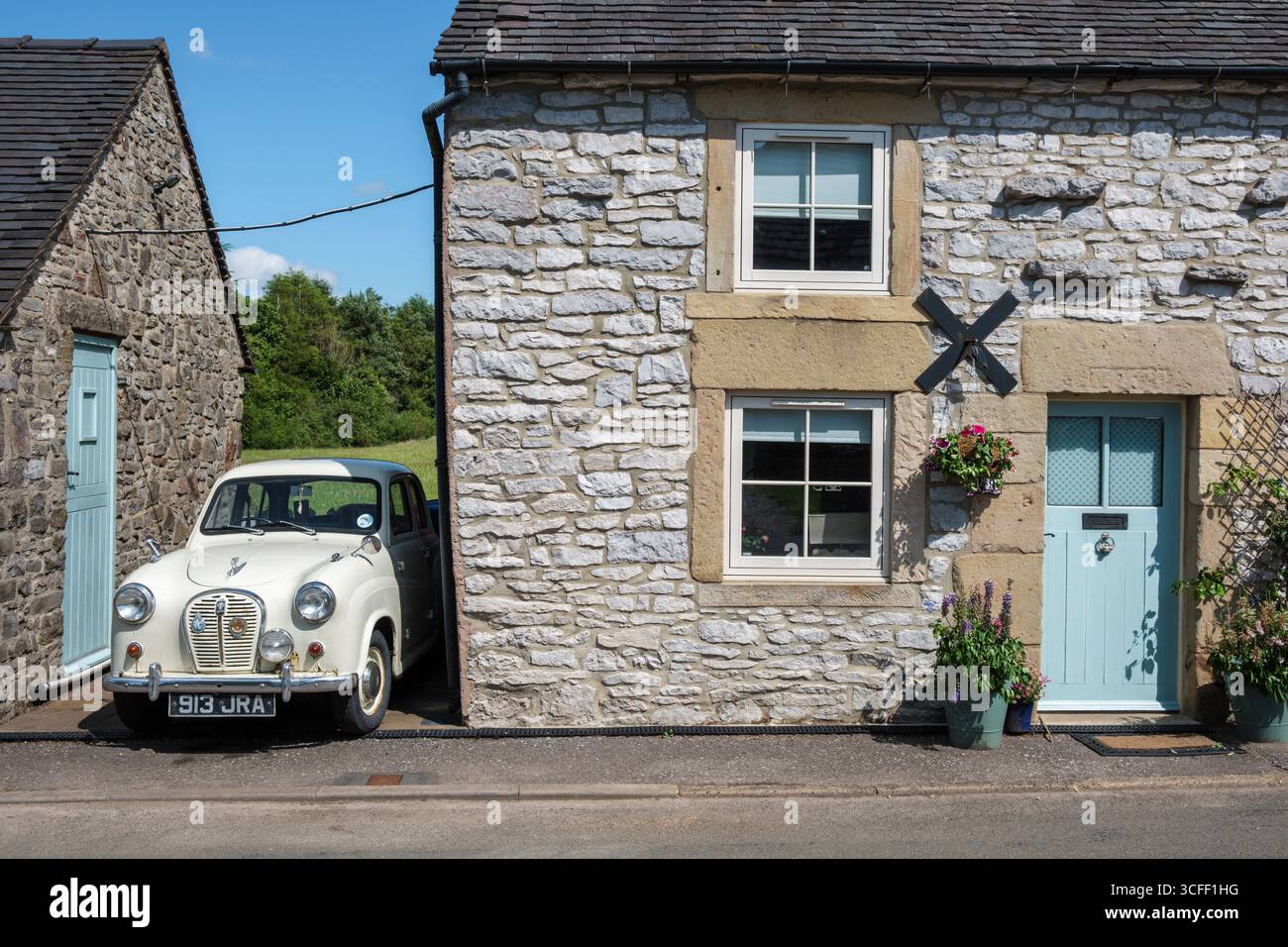 Un berline Austin A35 quatre portes vintage garé à l'extérieur d'un joli chalet dans le village Peak District de Biggin, Derbyshire Banque D'Images