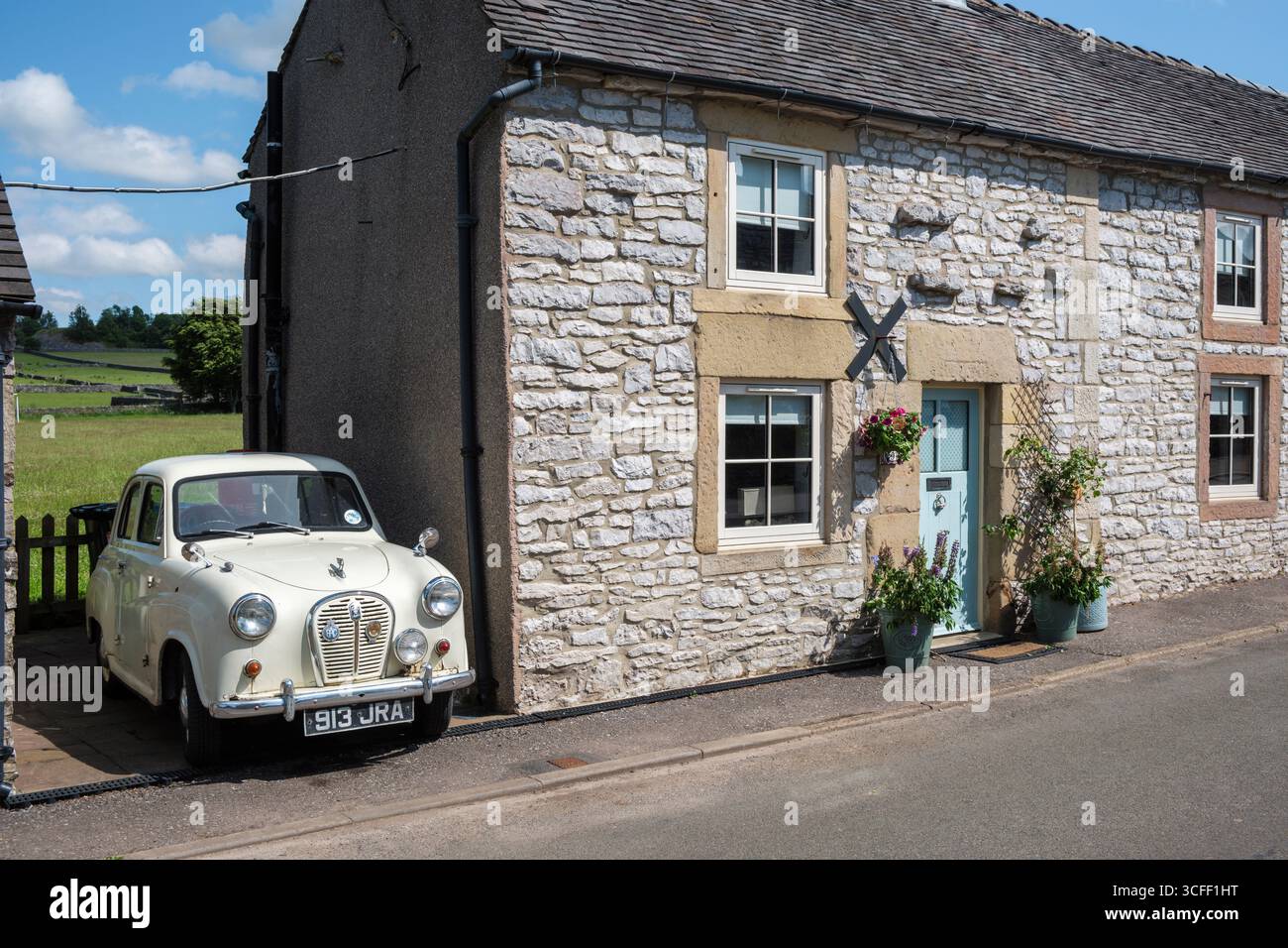 Un berline Austin A35 quatre portes vintage garé à l'extérieur d'un joli chalet dans le village Peak District de Biggin, Derbyshire Banque D'Images
